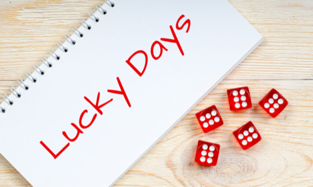 赤いサイコロとノートにluckydayの文字