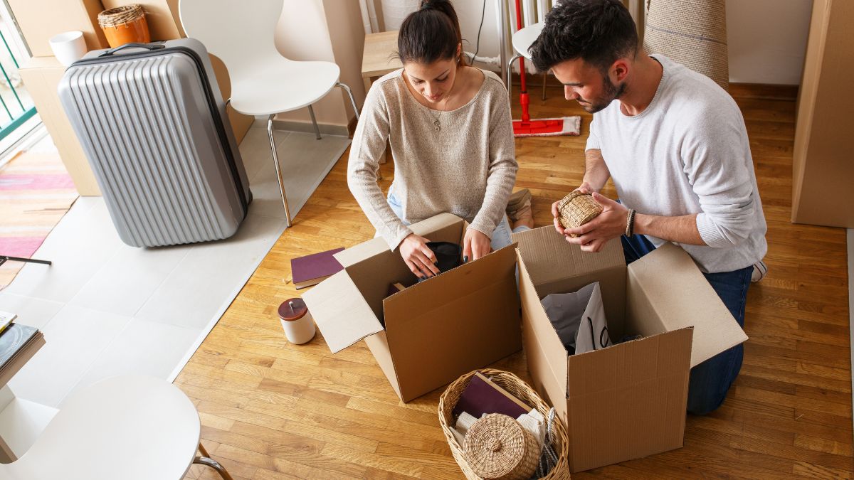 段ボールに荷物を詰める男女