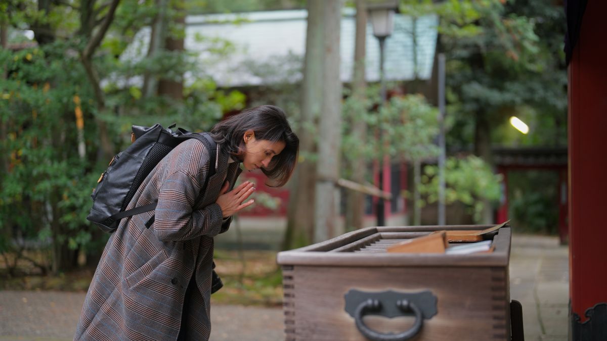 神社で参拝する女性